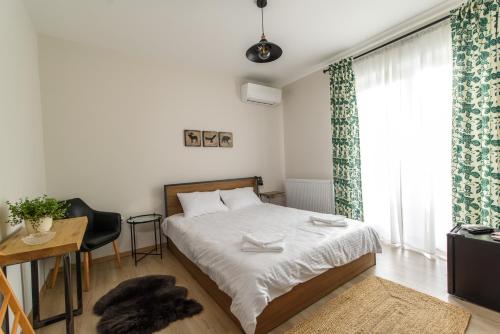 1 dormitorio con cama, escritorio y ventana en TamTam Urban en Cluj-Napoca