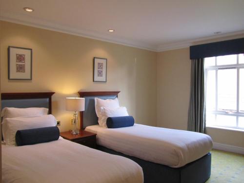 a hotel room with two beds and a window at Manor Hotel Solihull, BW Signature Collection in Bickenhill