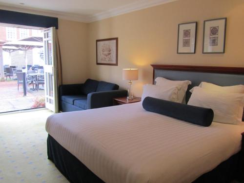 a hotel room with a bed and a living room at Manor Hotel Solihull, BW Signature Collection in Bickenhill