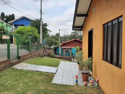 einen Hinterhof eines Hauses mit Garten in der Unterkunft Casa da Cris/Marcelo in Gramado