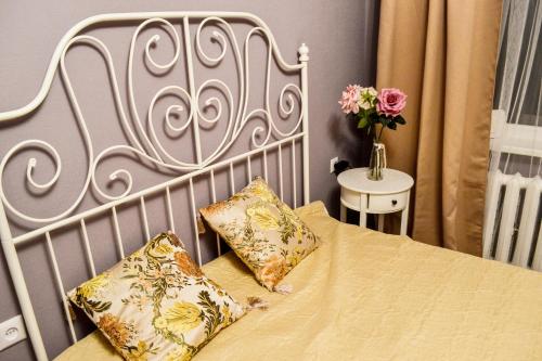 uma cama com uma cabeceira branca e duas almofadas em Cosy and Charming apartment em Alūksne