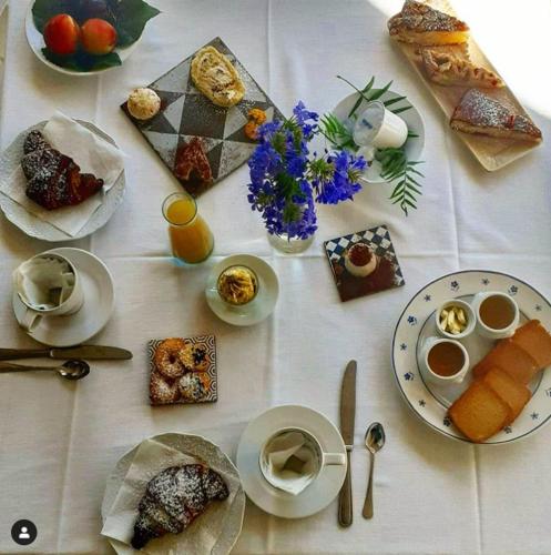Una mesa blanca con platos de comida encima. en Colle San Mauro, en Caltagirone