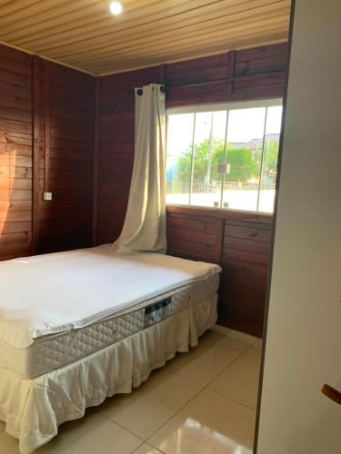 インビトゥバにあるCASA ACONCHEGANTE EM IBIRAQUERAのベッドルーム1室(窓、白いベッド1台付)