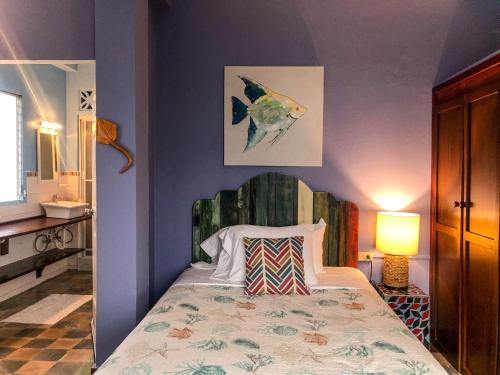 a bedroom with a bed in a room with purple walls at Casa Congo & Casa Rayo Verde - Restaurante - Galeria de arte in Portobelo