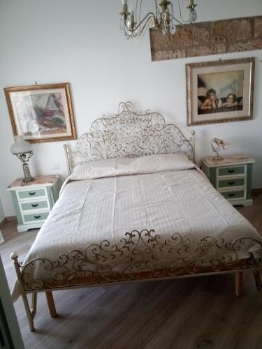 un letto in una camera da letto con due comodini e due tavoli di ASFODELIA-CORALLO ad Alghero