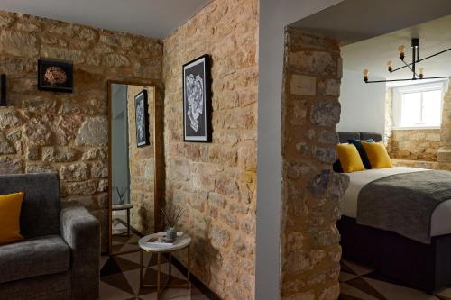 a bedroom with a bed and a stone wall at Hotel Indigo - Bath by IHG in Bath