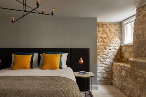 a bedroom with a bed with yellow and blue pillows at Hotel Indigo - Bath by IHG in Bath