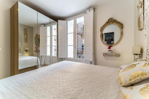 een slaapkamer met een groot bed en een spiegel bij Suite Capitán 2 in Cádiz