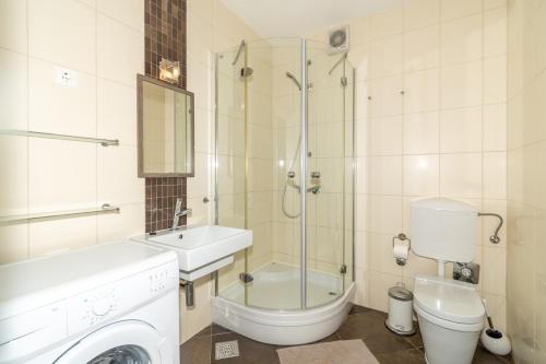ein Bad mit einem WC, einem Waschbecken und einer Dusche in der Unterkunft Trstenik Beach Apartment in Split