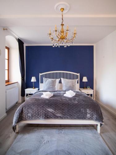 a bedroom with a large bed with a blue wall at ApartOne Altstadt-Hotel in Bautzen