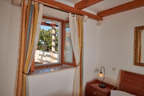 a window in a room with a bed and a lamp at Villa Sole in Cavtat
