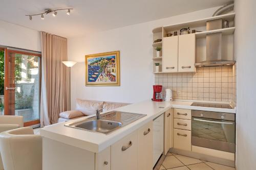 a kitchen with white cabinets and a sink at Villa Sole in Cavtat