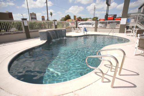 una piscina con 2 sillas y una mesa en Texas Inn McAllen Airport, en McAllen