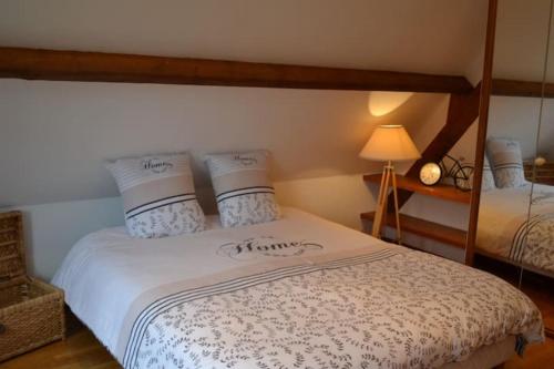 a bedroom with a bed with white sheets and pillows at Studio du Domaine de la Petitière in Bonneville-la-Louvet