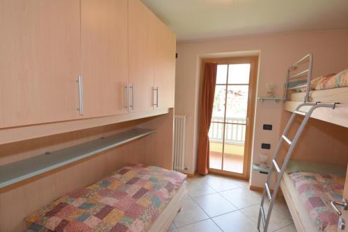 a bedroom with a bunk bed and a ladder at Casa Fior del Soreie in Pozza di Fassa
