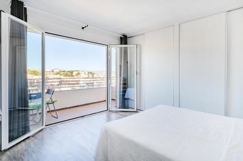 a bedroom with a white bed and a balcony at Beach Suite, city & mountain view in Alicante