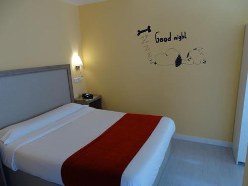 a bedroom with a bed and a sign on the wall at Hotel Mexico in Madrid