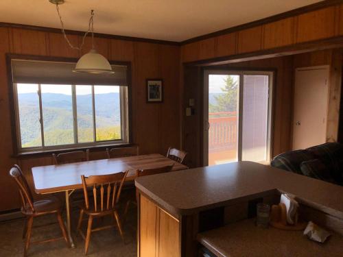 ein Wohnzimmer mit einem Tisch, Stühlen und einem Fenster in der Unterkunft 301 D Summit Dr. , Snowshoe Mountains, WV 26209 in Snowshoe