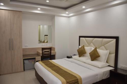 a bedroom with a large bed and a mirror at Lemon Green Residency - Hotel and Serviced Apartments in New Delhi