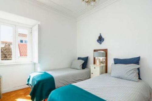 a bedroom with two beds with blue and white at Blue Vintage House in Setúbal