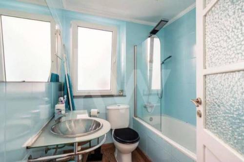 a bathroom with a sink and a toilet and a shower at Blue Vintage House in Setúbal