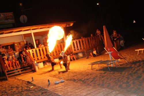 a couple of people with fire in front of a building at Park Hotel Villa Americana in Rodi Garganico