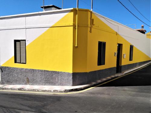 un edificio amarillo y blanco con ventanas en una calle en Casa Jashmine, en Arguayo