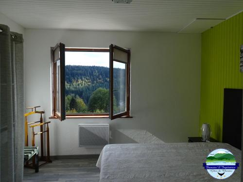 a bedroom with a window with a view of a forest at Domaine L'Impératrice in Plombières-les-Bains