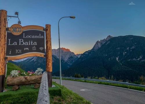 a sign for the la bahia sign on the side of a road at Locanda La Baita in Santo Stefano di Cadore