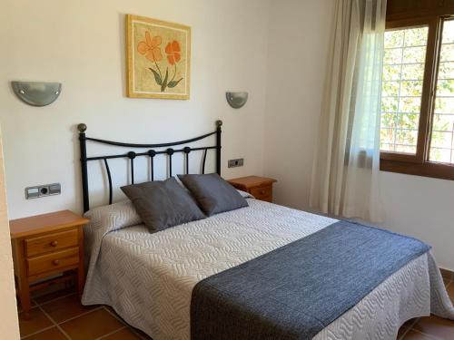 a bedroom with a bed with a blue comforter at Villa Montserrat 3, Terrace & Pool in Sant Martí d’Empúries