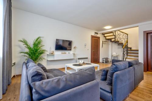 Apartment Grey Mountain في زلاتيبور: غرفة معيشة مع كنبتين زرقاوين وطاولة