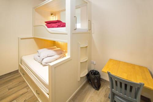 a room with a bunk bed with a desk and a chair at Canolfan Y Fron in Caernarfon