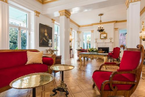 a living room with a red couch and chairs at 20 South Battery in Charleston