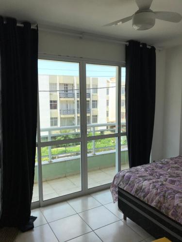 ein Schlafzimmer mit einem Bett und einem großen Fenster in der Unterkunft Casa paraíso 2 in Arraial do Cabo