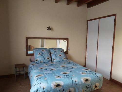 a bedroom with a bed with a blue comforter at Ô miroir... sans détour dis-moi tout de ce séjour in Francescas