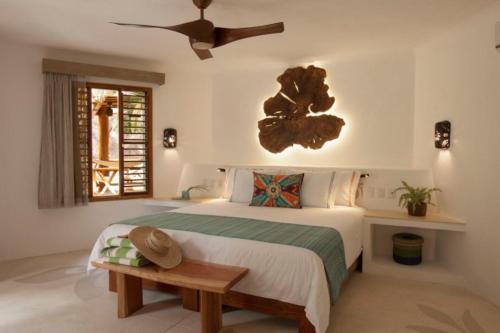 a bedroom with a bed and a ceiling fan at Mahekal Beach Front Resort & Spa in Playa del Carmen