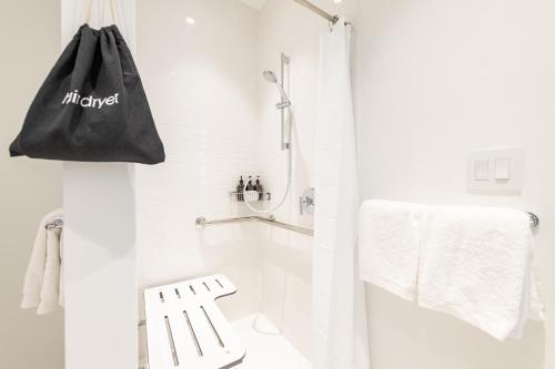 a white bathroom with a black bag hanging on the wall at The Islands of Islamorada in Islamorada