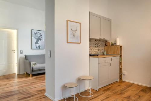 a kitchen with a counter and two stools in a room at CITY Apartments in zentraler Lage mit Parkplatz - nah an GOP, Kliniken, Bali-Therme in Bad Oeynhausen