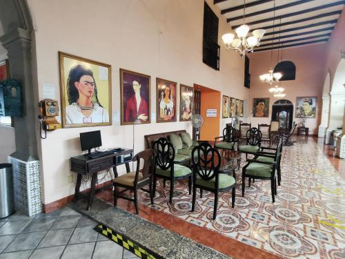 a room with a table and chairs and pictures on the wall at Hotel Doralba Inn in Mérida