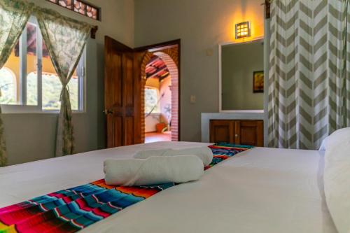 a bedroom with two beds and a mirror at Casa Berita in Yelapa