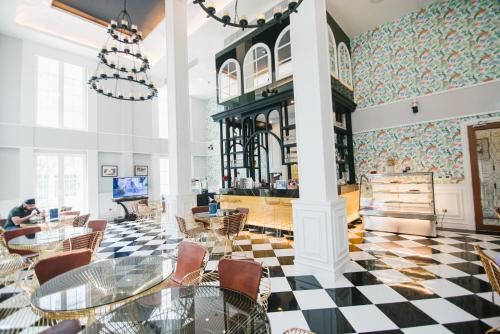 een eetkamer met tafels en stoelen en een geruite vloer bij Grand Florida Pattaya By TheBest Management in Na Jomtien