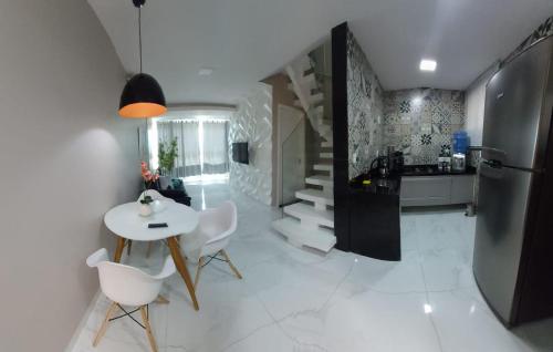 a kitchen with a table and chairs and a refrigerator at Apartamento Duplex na Praia Grande 108 VISTA MAR in Arraial do Cabo