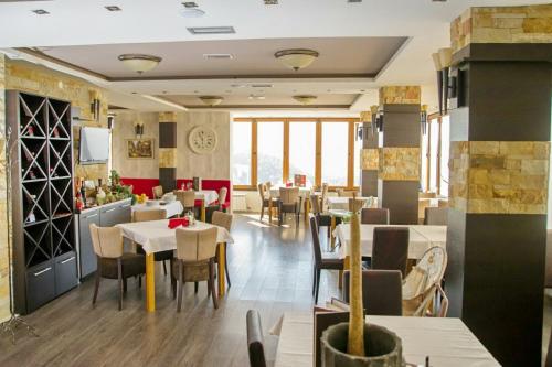 Kophill L36 Milmari في كوباونيك: مطعم يحتوي على طاولات وكراسي في الغرفة