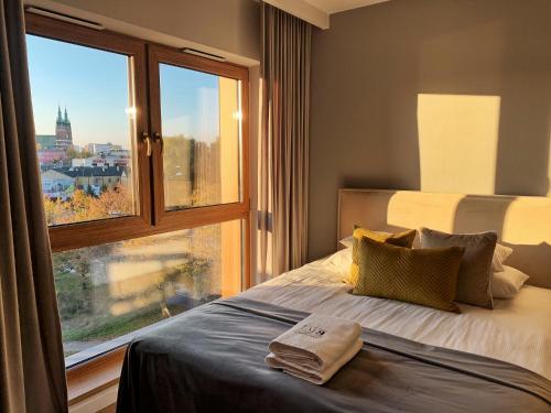 een slaapkamer met een bed en een groot raam bij LM Ventus Apartment in Kielce