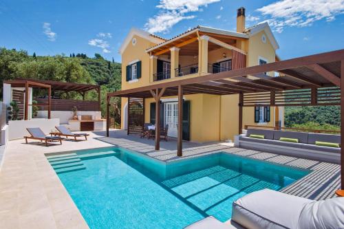 a house with a swimming pool in front of a house at Villa Corfu Melody in Vouníon