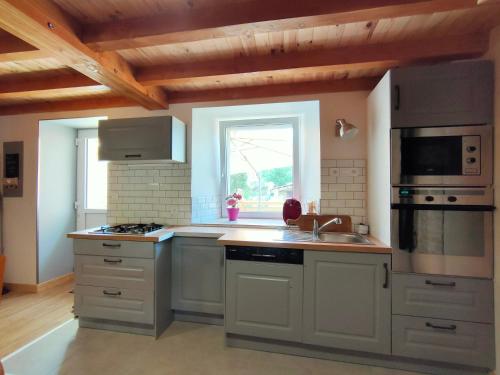 a kitchen with a sink and a stove top oven at Les Petites Poussières in Bas-en-Basset