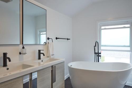 une salle de bain blanche avec une baignoire et un lavabo dans l'établissement Holly Lodge - Ski Windham Hunter Catskills, à Prattsville