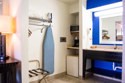 La salle de bains est pourvue d'un lavabo et d'un miroir. dans l'établissement Blue Jay Inn & Suites, à Sallisaw