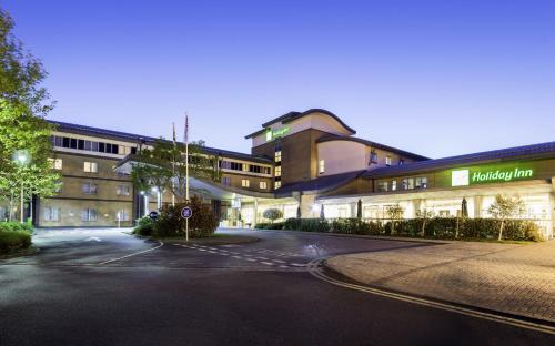 an empty street in front of a building at night at Holiday Inn Oxford by IHG in Oxford