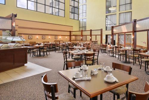 a restaurant with tables and chairs in a room at Ramada Plaza by Wyndham Sheridan Hotel & Convention Center in Sheridan